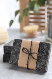 Photo of Natural tar soap on light grey table, closeup