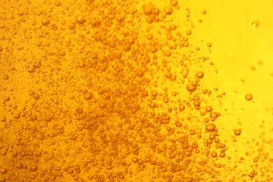 Photo of Tasty beer with bubbles as background, closeup