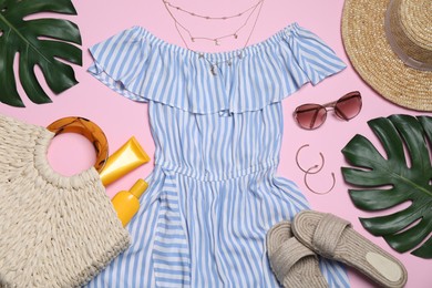 Flat lay composition with stylish blue dress and beach accessories on pink background