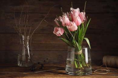 Beautiful bouquet of spring pink tulips on wooden table