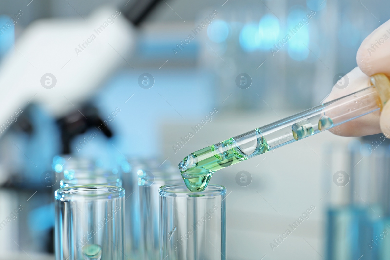 Photo of Analyst dripping reagent into test tube with sample at laboratory, closeup. Chemical analysis