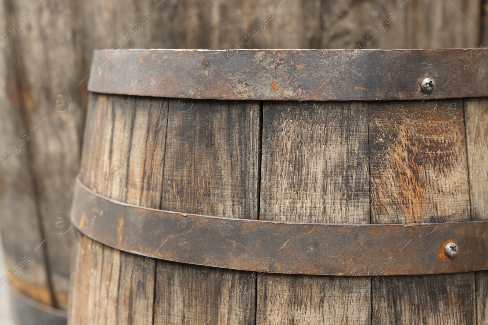 Photo of Traditional wooden barrel on blurred background, closeup. Wine making