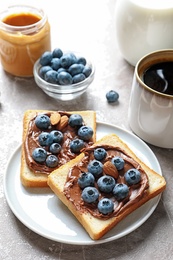 Toast bread with blueberries and chocolate paste on table