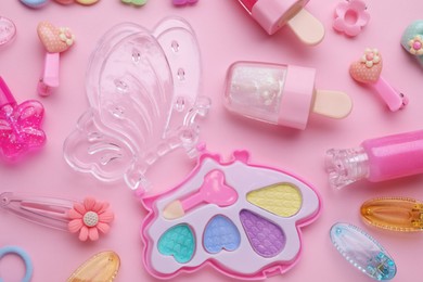 Photo of Eye shadow palette and other decorative cosmetics for kids on pink background, flat lay
