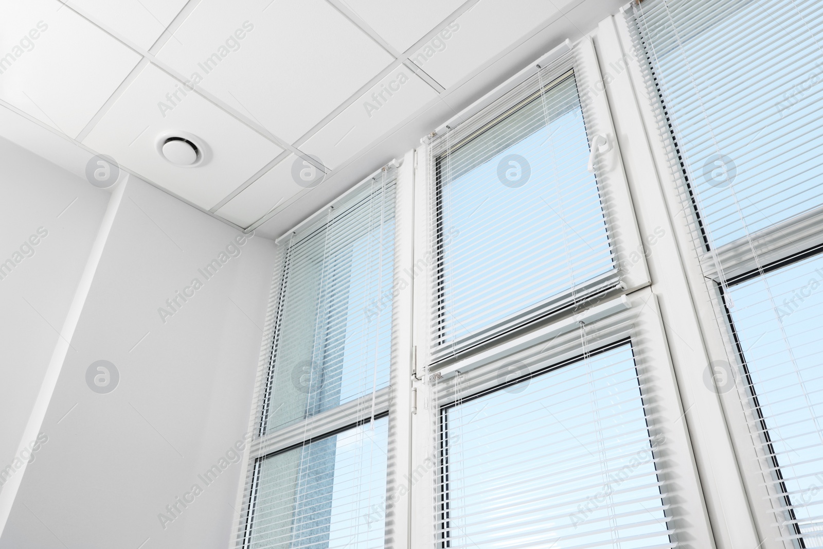 Photo of Large window with horizontal blinds indoors, low angle view