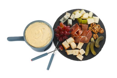 Photo of Fondue with tasty melted cheese, forks and different snacks isolated on white, top view