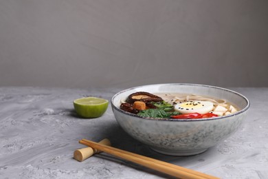 Delicious vegetarian ramen served on grey table, space for text. Noodle soup