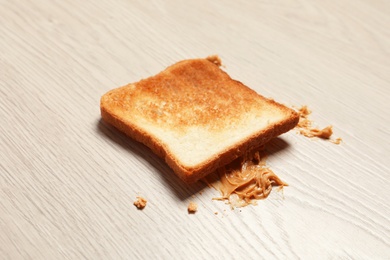 Overturned toast bread with peanut butter on floor