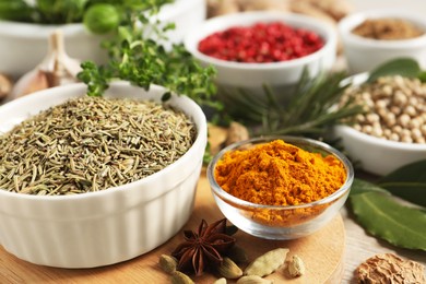 Different herbs and spices on wooden table, closeup