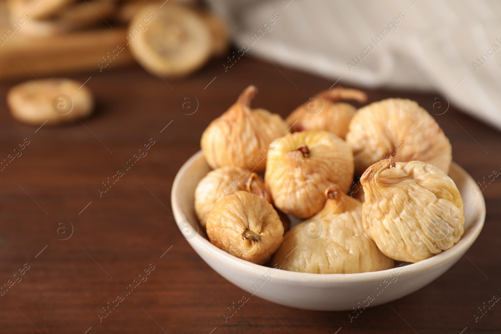Photo of Tasty dried figs on wooden table, closeup. Space for text