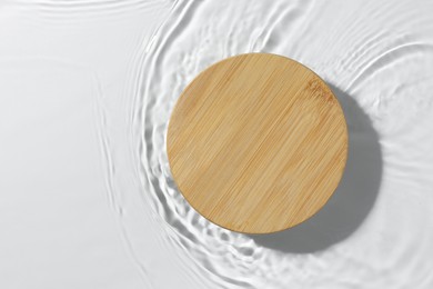 Photo of Presentation of product. Wooden podium in water on white background, top view. Space for text