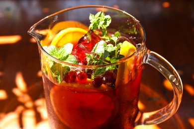Photo of Jug with delicious refreshing cocktail, closeup