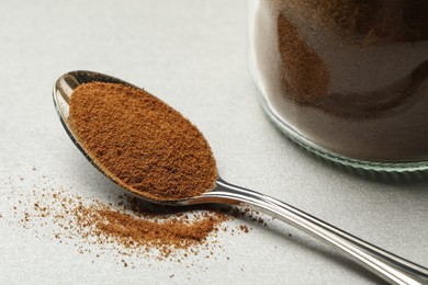 Spoon of chicory powder on light grey table, closeup