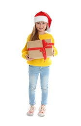 Photo of Cute little girl in Santa hat with Christmas gift on white background