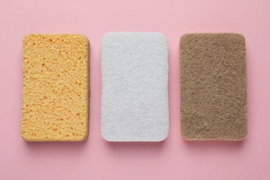 Photo of New sponges on pink background, flat lay