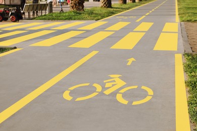 Photo of Bike lane with painted yellow bicycle sign and pedestrian crossing outdoors