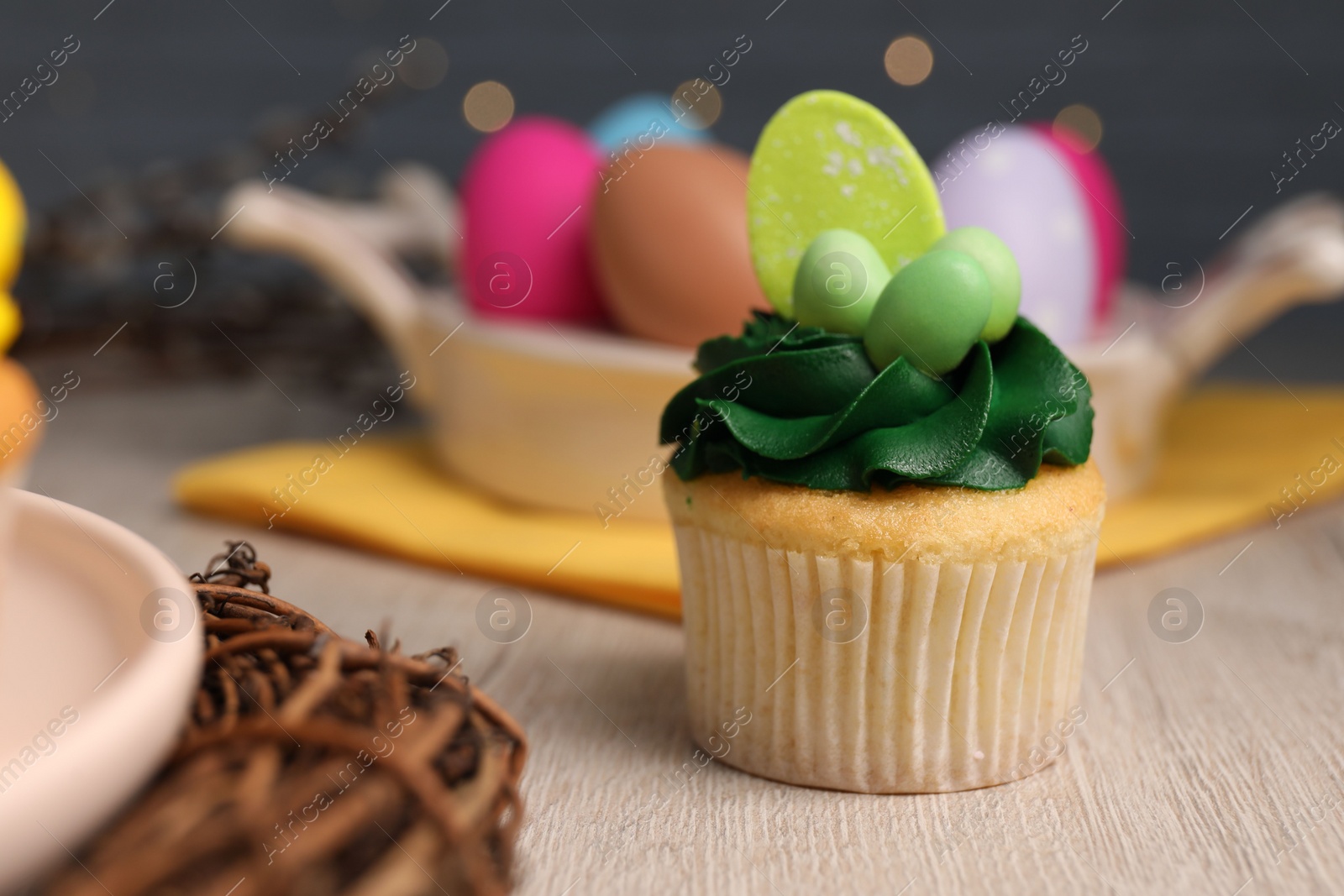 Photo of Tasty cupcake with Easter decor on wooden table, closeup