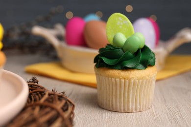 Photo of Tasty cupcake with Easter decor on wooden table, closeup