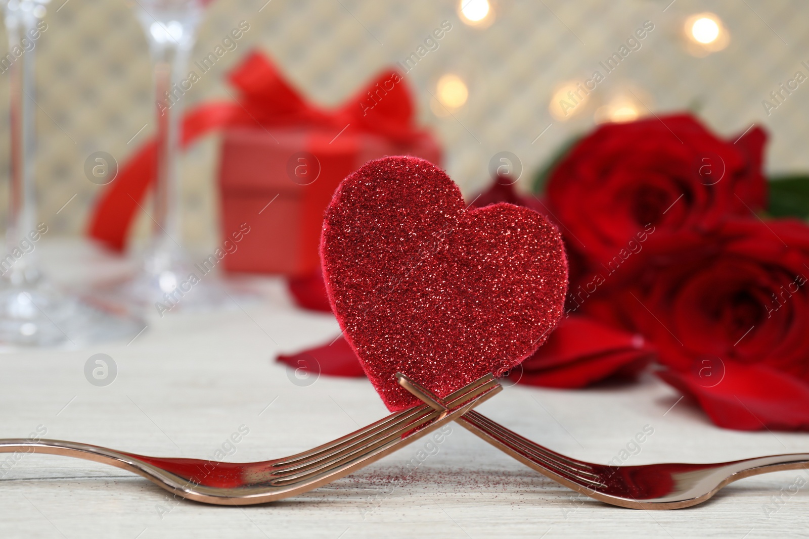 Photo of Forks and decorative heart on white table. Romantic place setting