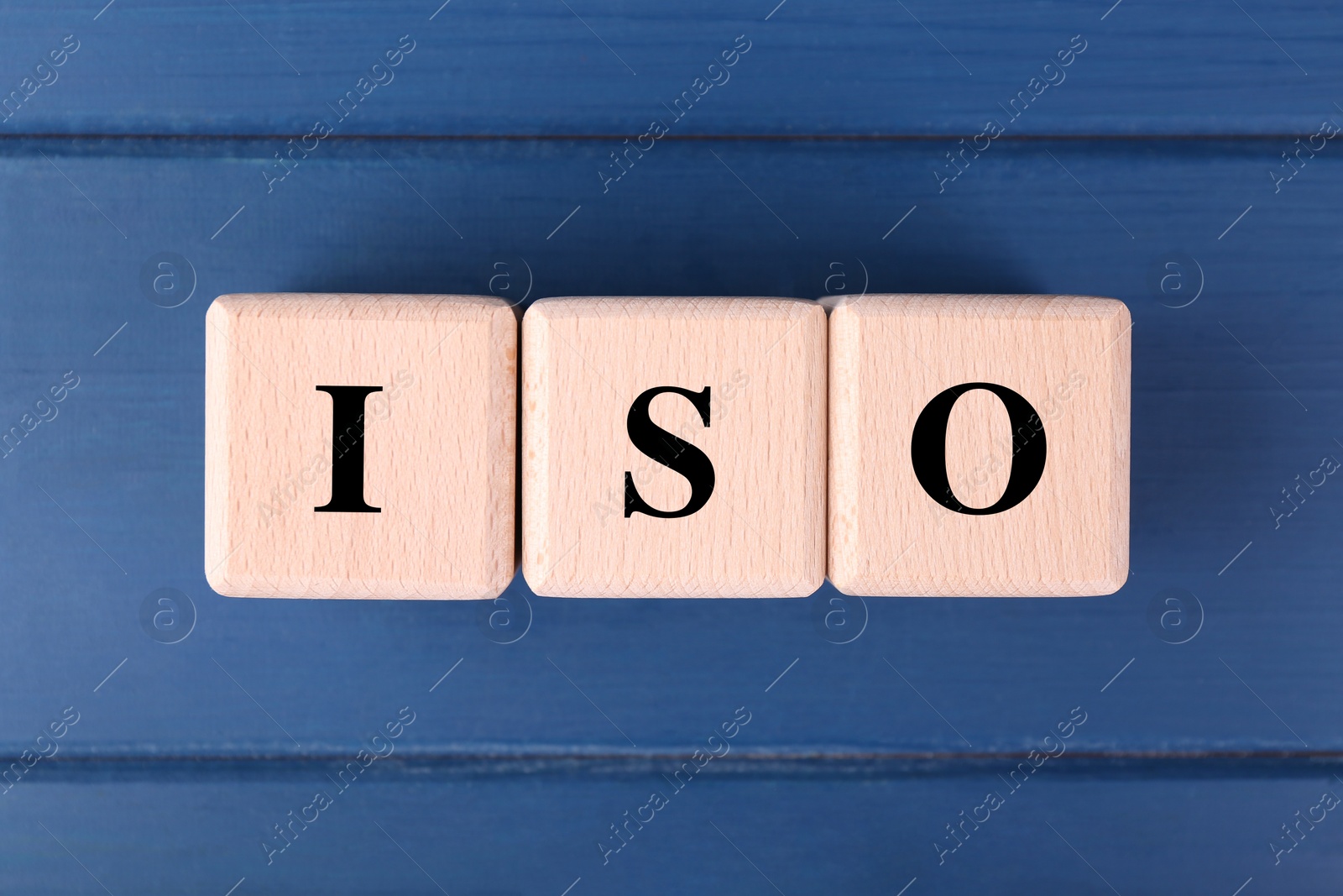 Photo of International Organization for Standardization. Cubes with abbreviation ISO on blue wooden table, top view