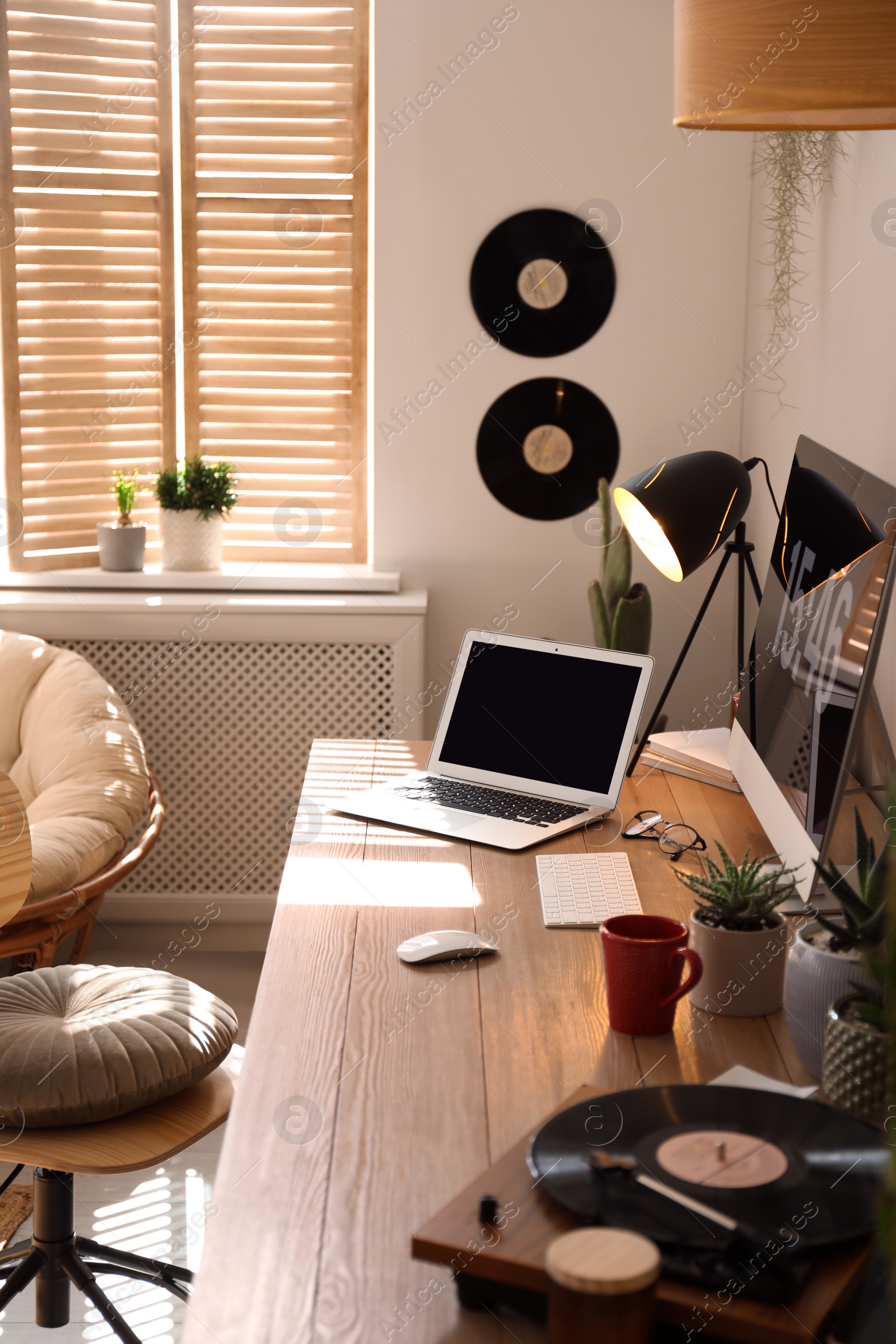 Photo of Modern computer and laptop on wooden desk in room. Interior design