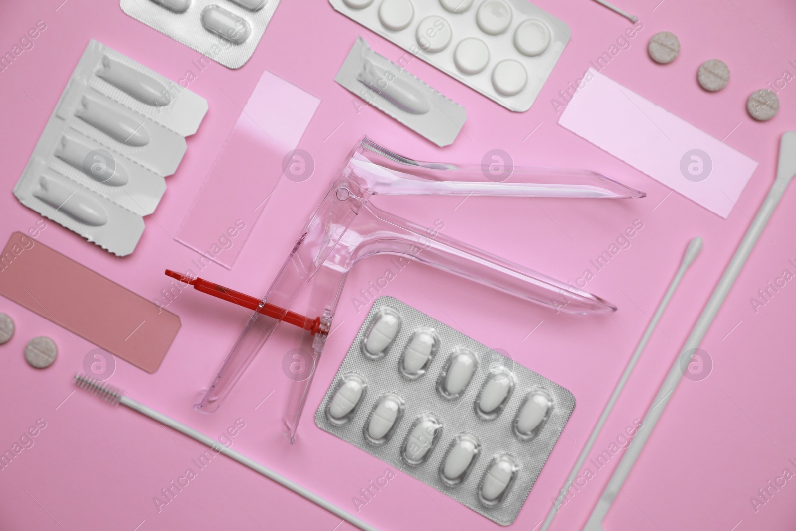 Photo of Sterile gynecological examination kit and medicaments on pink background, flat lay