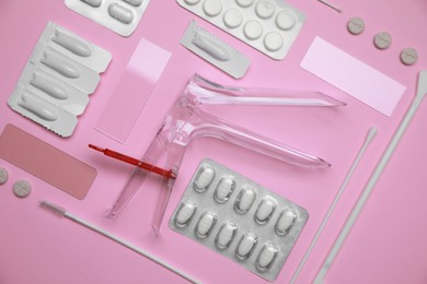 Sterile gynecological examination kit and medicaments on pink background, flat lay