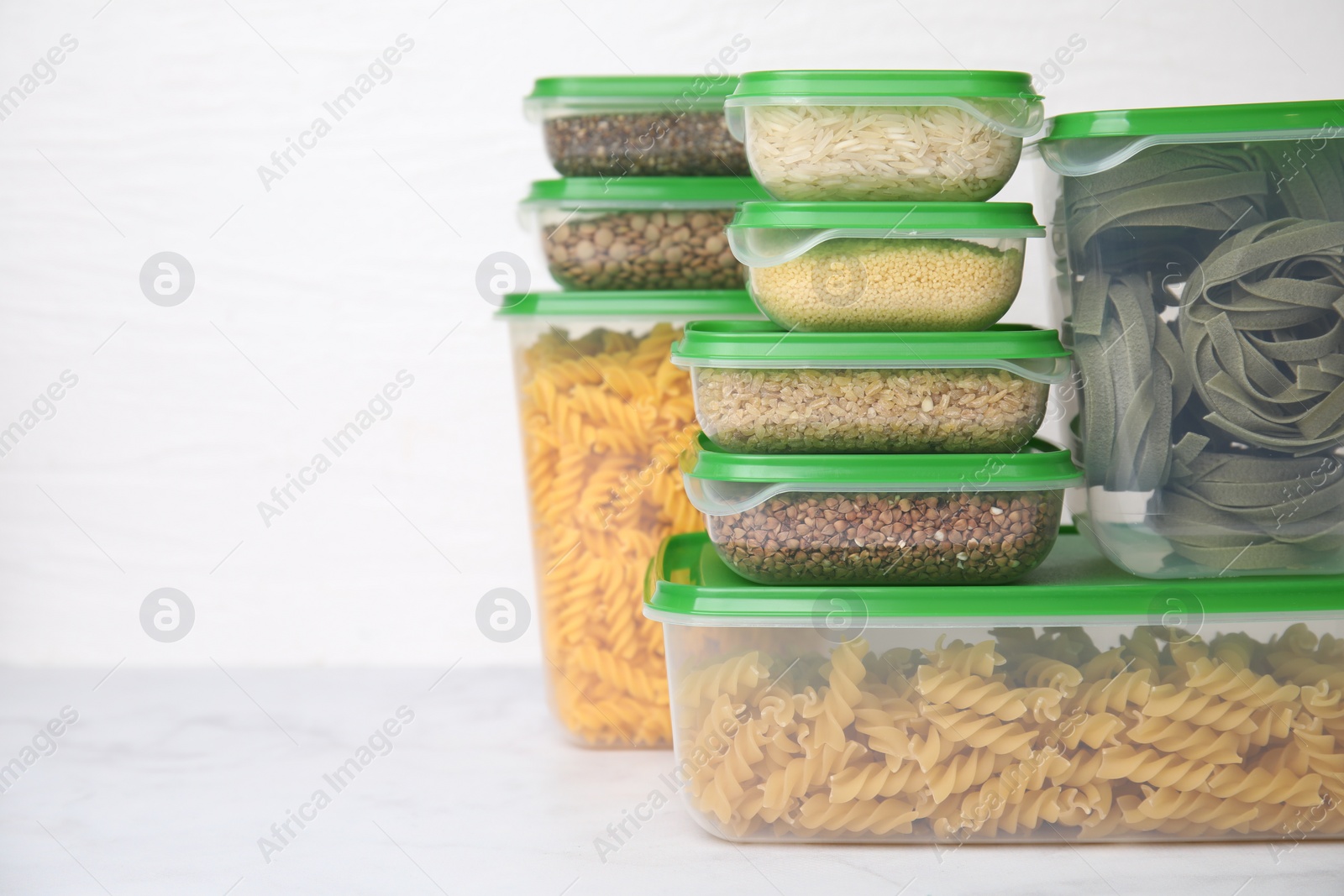 Photo of Plastic containers filled with food products on white table. Space for text