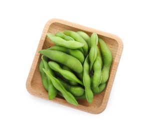 Photo of Wooden plate with green edamame pods on white background, top view