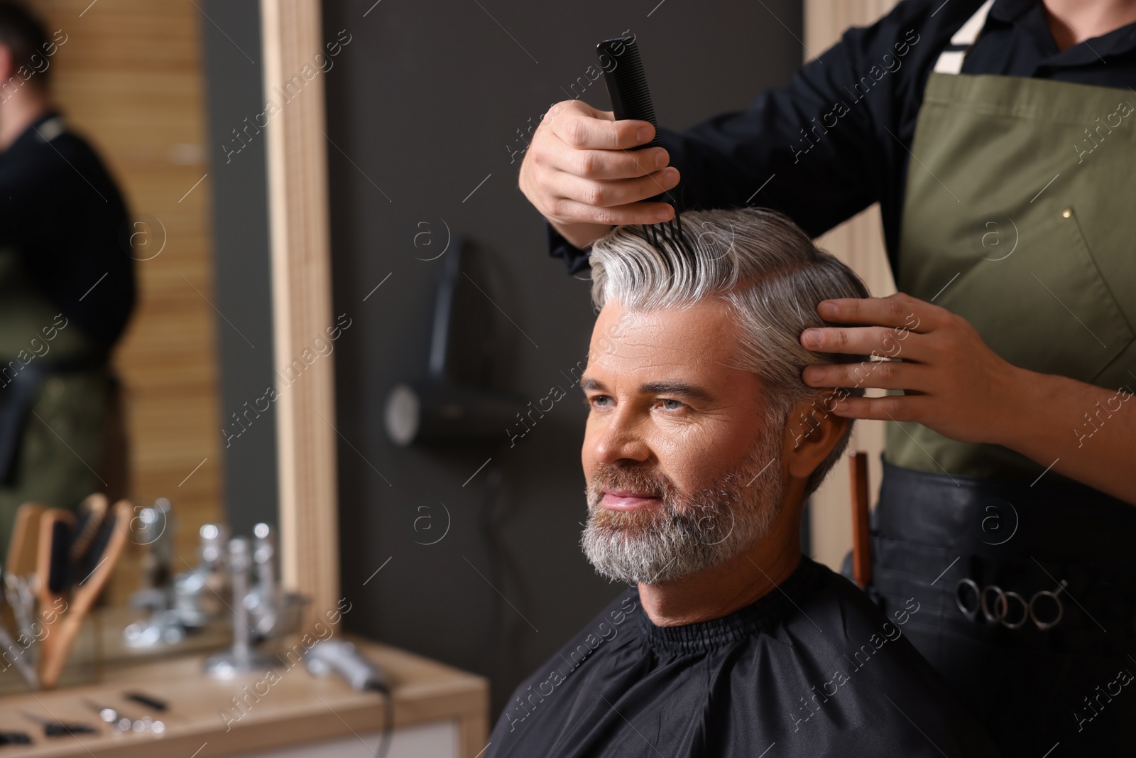 Photo of Hair styling. Professional hairdresser working with client in barbershop, closeup