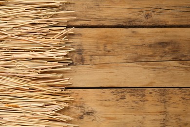 Dried hay on wooden background, flat lay. Space for text