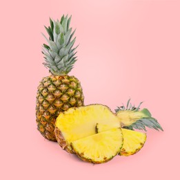 Image of Cut and whole pineapples on pink background