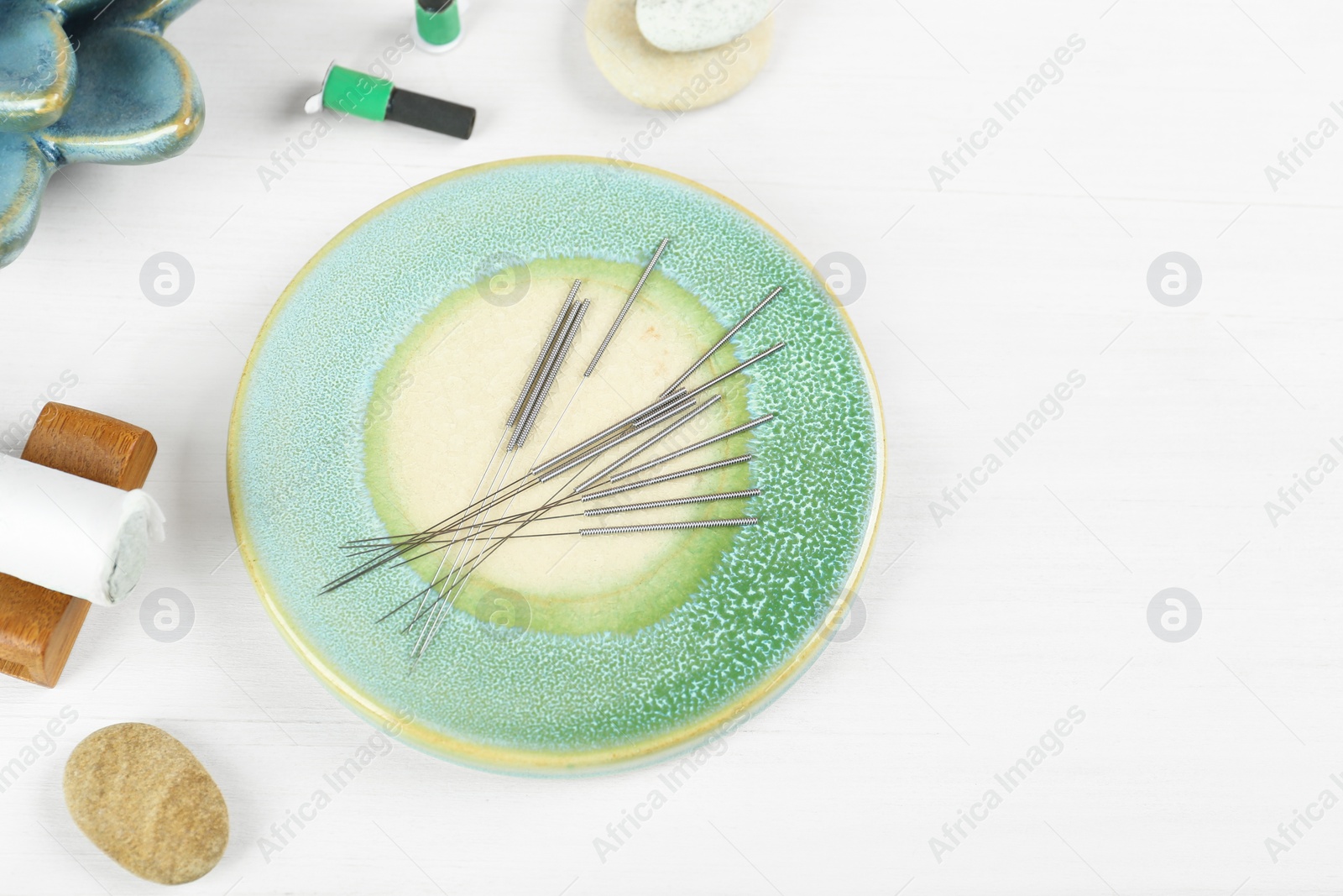 Photo of Flat lay composition with acupuncture needles on white wooden table. Space for text