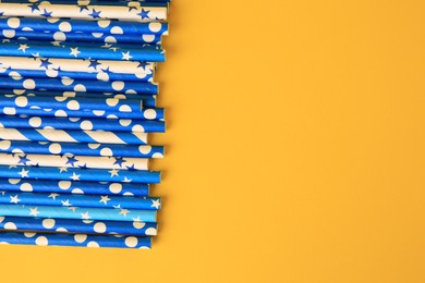 Photo of Many paper drinking straws on yellow background, flat lay. Space for text