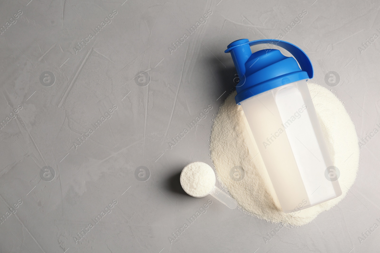 Photo of Bottle, protein powder and space for text on grey background, top view. Preparing shake