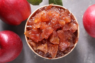 Photo of Delicious apple jam and fresh fruits on grey table, flat lay