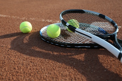 Tennis balls and rackets on clay court