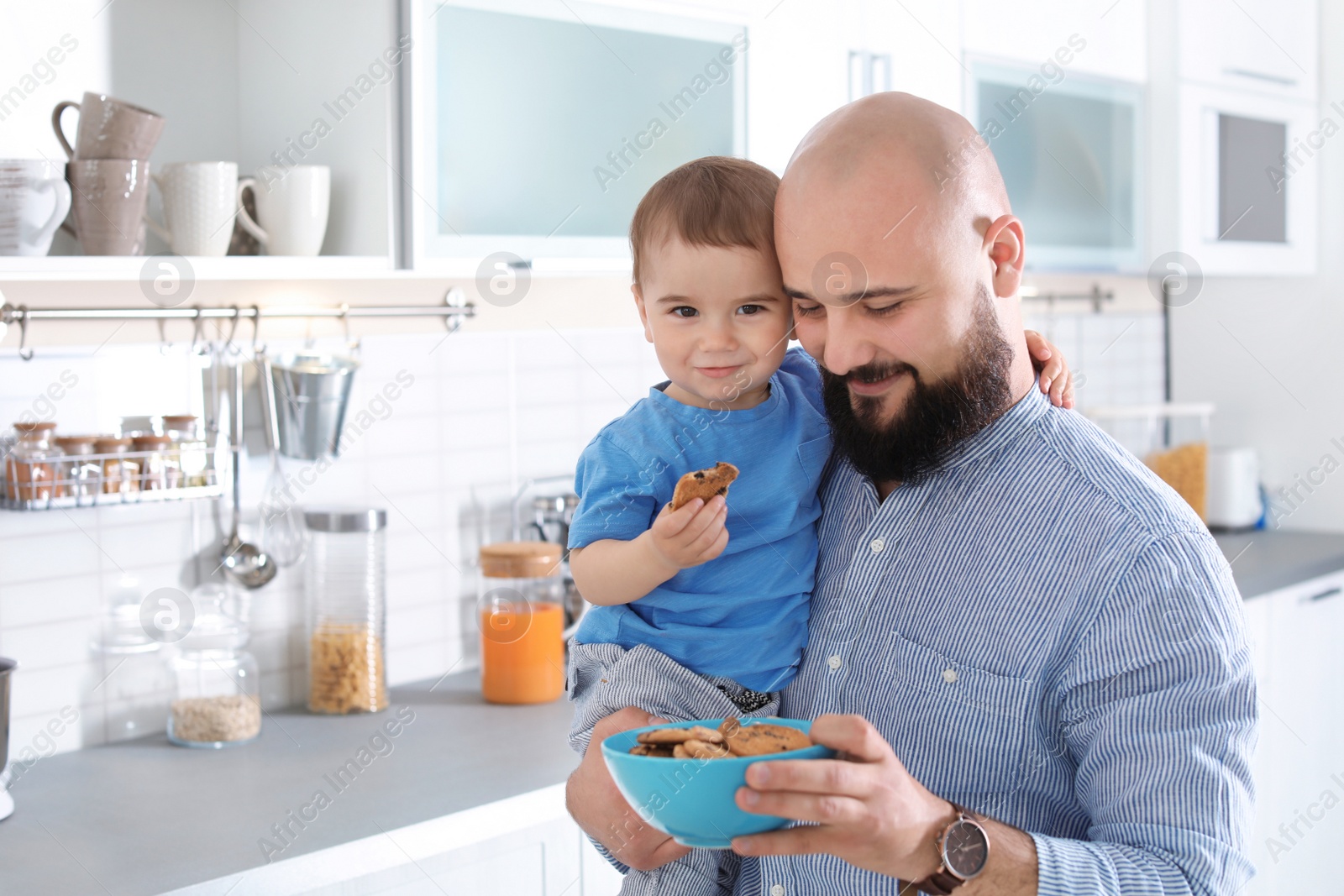 Photo of Dad having breakfast with little son in kitchen