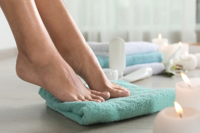 Photo of Closeup view of woman with beautiful feet on towel indoors, space for text. Spa treatment