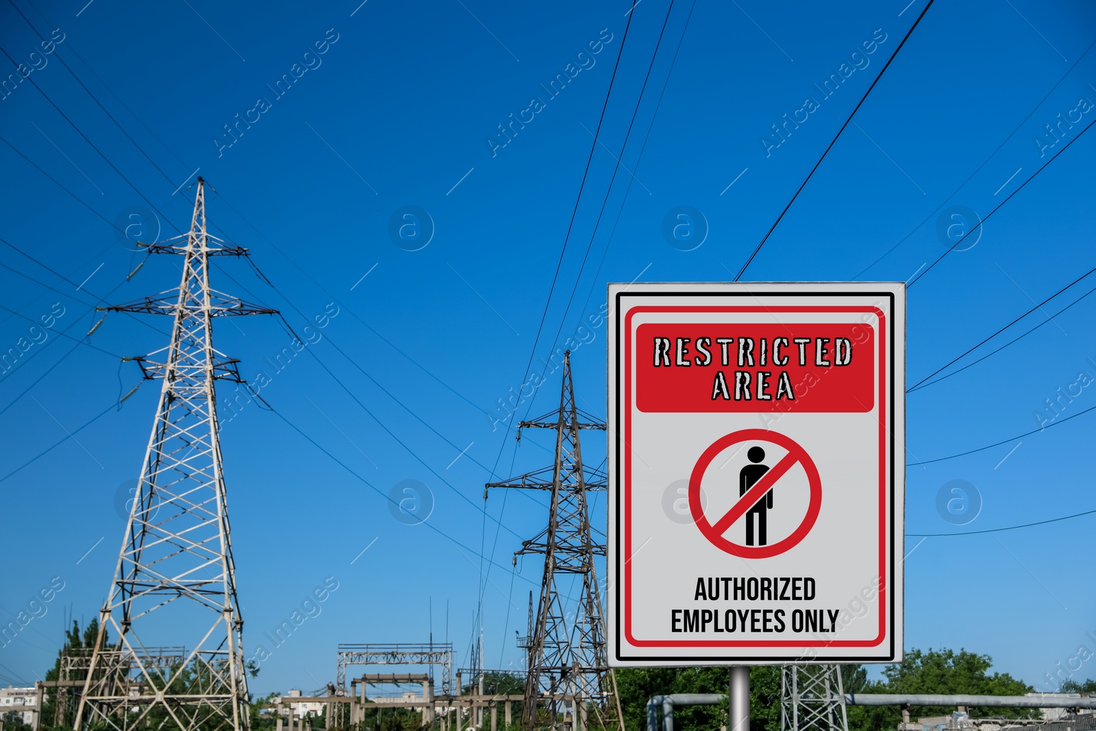 Image of Sign with text Restricted Area Authorized Employees Only near high voltage towers outdoors