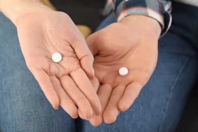 Photo of Man and woman holding pills, closeup view
