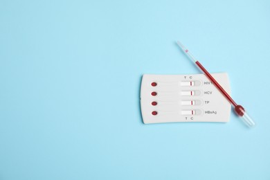 Photo of Disposable express hepatitis test kit on light blue background, flat lay. Space for text