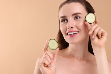 Photo of Beautiful woman with pieces of cucumber on beige background. Space for text