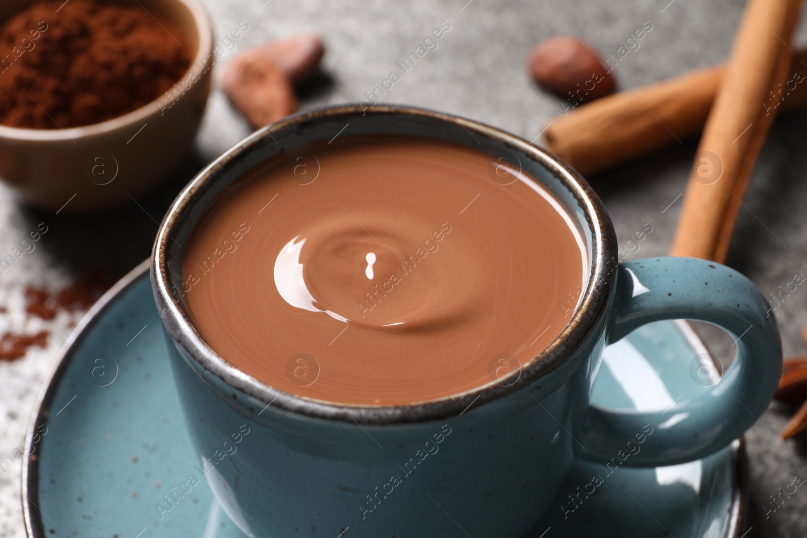 Photo of Yummy hot chocolate in cup on grey table, closeup