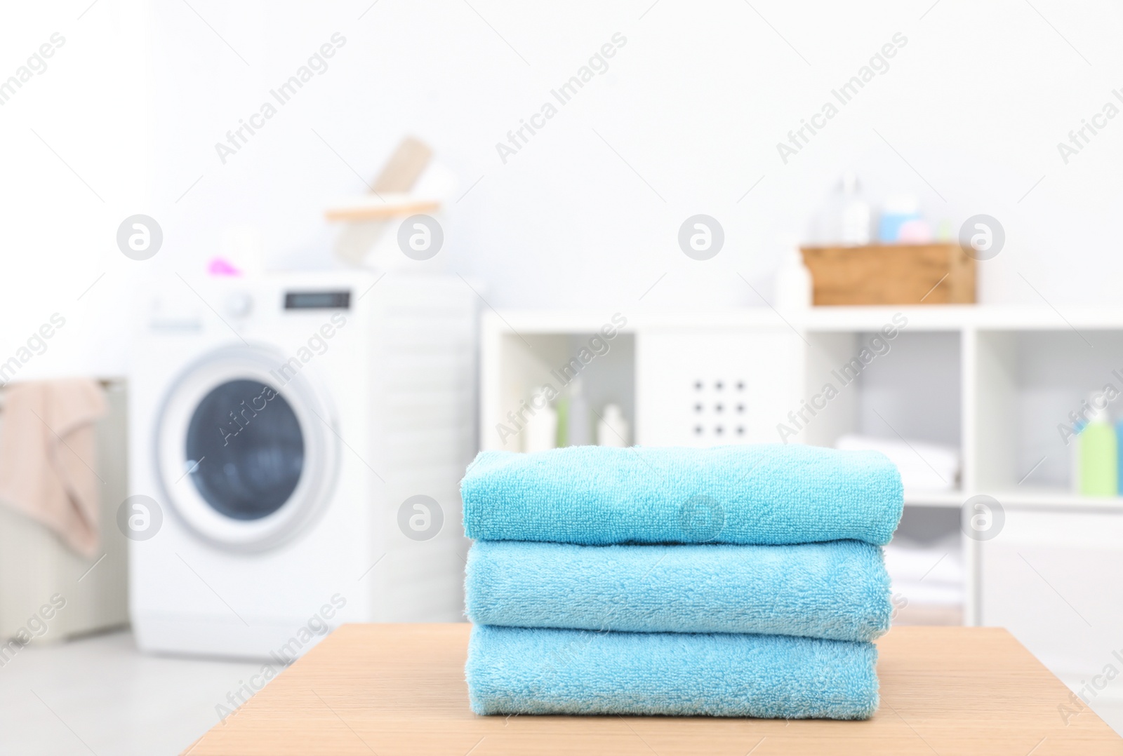 Photo of Stack of clean towels on table in bathroom.  Space for text