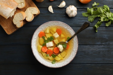 Photo of Flat lay composition with fresh homemade chicken soup on wooden background, top view