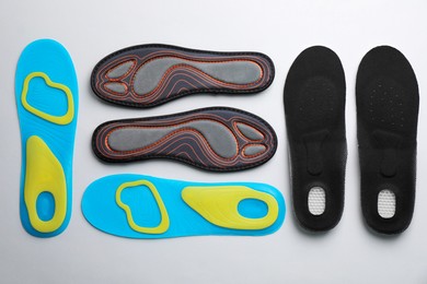 Photo of Pairs of insoles on light gray background, flat lay