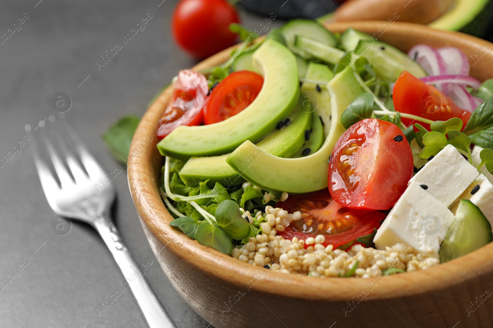 Photo of Delicious avocado salad with quinoa on grey table, closeup