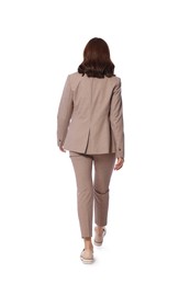 Photo of Woman in formal suit walking on white background, back view