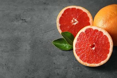 Photo of Fresh tasty grapefruits on grey table. Space for text